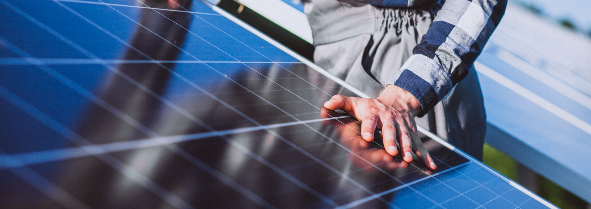 Man worker in the firld by the solar panels